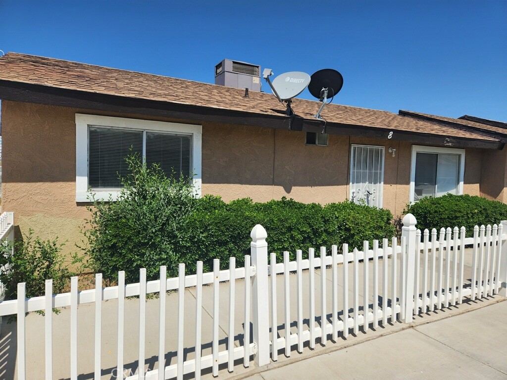 15418 Bear Valley Road, Unit 8 Victorville, CA 92395 - Photo 2 of 8 a front view of a house with a garden