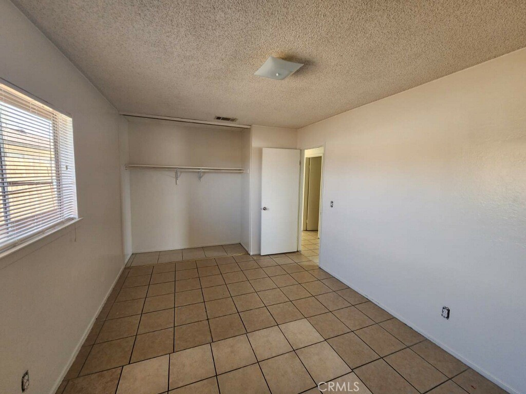 15418 Bear Valley Road, Unit 8 Victorville, CA 92395 - Photo 4 of 8 a view of an empty room and window