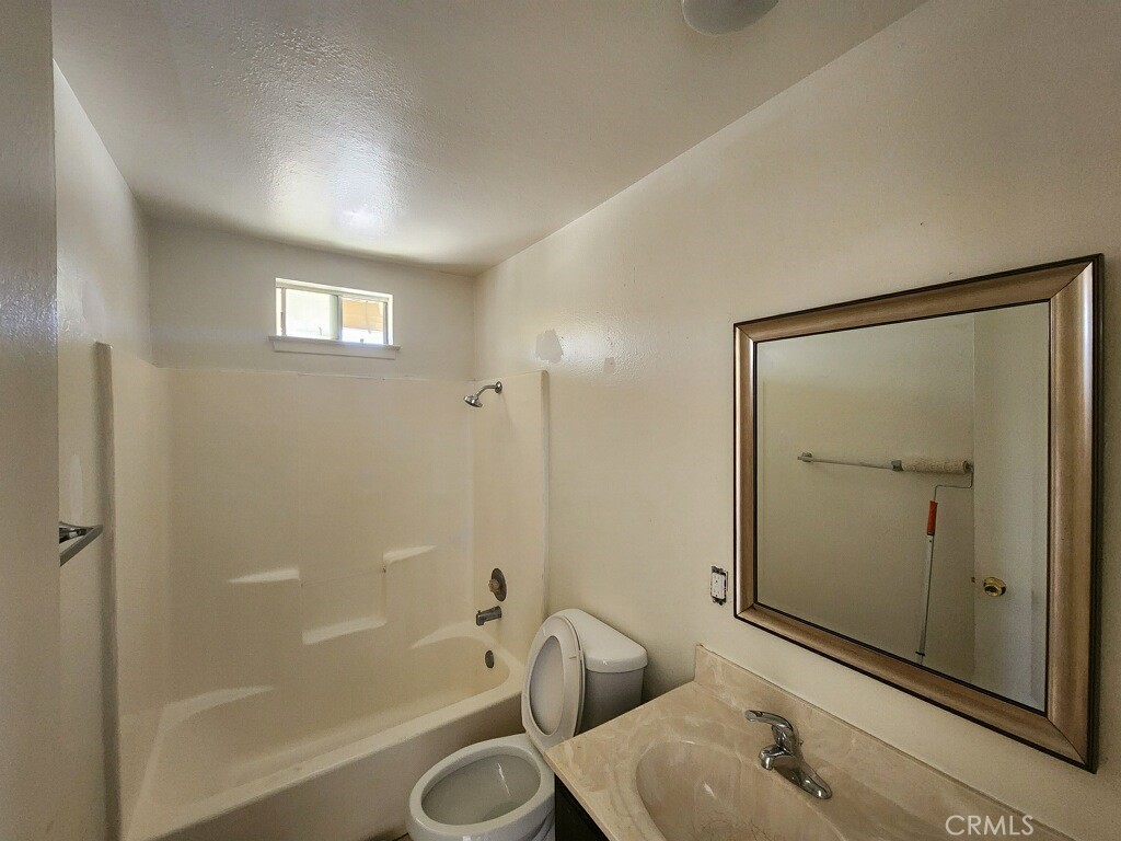 15418 Bear Valley Road, Unit 8 Victorville, CA 92395 - Photo 7 of 8 a bathroom with a sink and a mirror