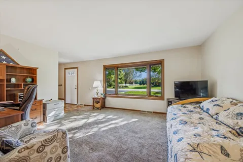 a bed sitting in a bedroom next to a window with tv