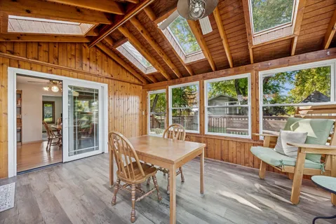 a dining room with wooden floor and furniture