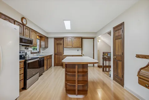 a kitchen with stainless steel appliances a stove top oven and a refrigerator