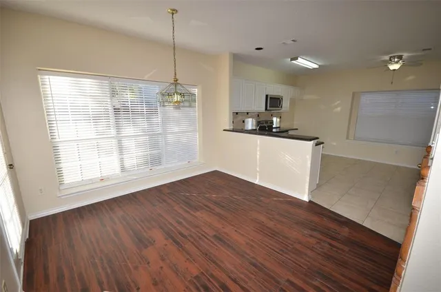 a kitchen with stainless steel appliances granite countertop a sink a microwave cabinets and wooden floor