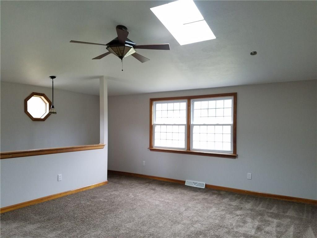 154 Stoup Road Mars, PA 16046 - Photo 19 of 25 Large Living Room with stairs to Lower Level. Skylight, ceiling fan/light & brand new carpeting. Door to small deck.