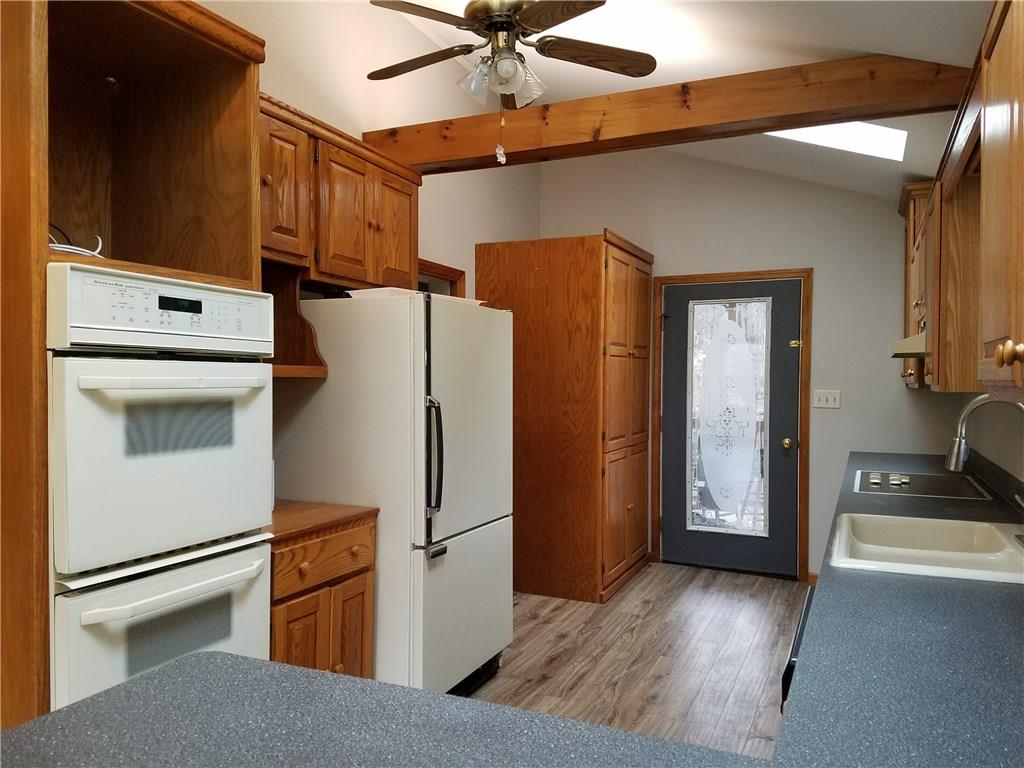 154 Stoup Road Mars, PA 16046 - Photo 6 of 25 Large Kitchen with brand new flooring! Glass door to large covered deck. Open to Breakfast Room. Ceiling fan/light & Beamed ceiling with sky lights for extra brightness! Eat-at counter space.