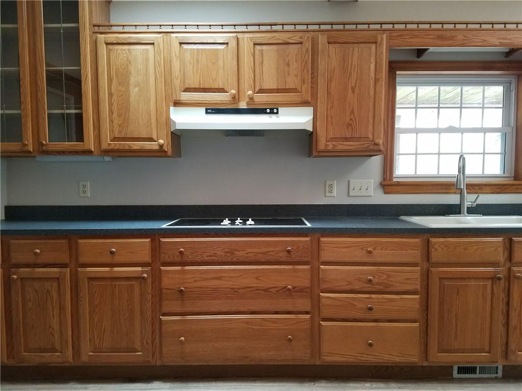 154 Stoup Road Mars, PA 16046 - Photo 8 of 25 Large Kitchen with brand new flooring! Glass door to large covered deck. Open to Breakfast Room. Ceiling fan/light & Beamed ceiling with sky lights for extra brightness! Eat-at counter space.