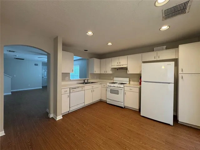 a kitchen with white cabinets and white appliances