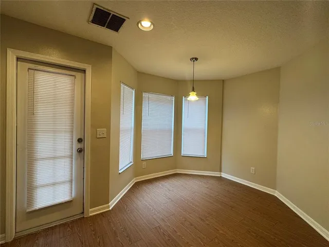 an empty room with wooden floor and door