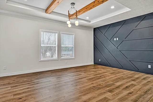 a kitchen with stainless steel appliances a refrigerator a sink dishwasher a stove and white cabinets with wooden floor