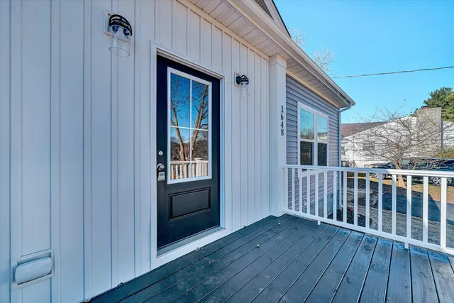 a view of empty room with wooden floor and ceiling fan