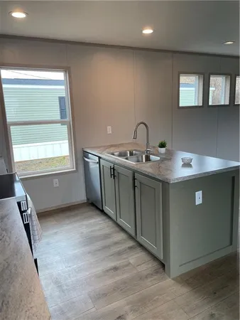 a kitchen with granite countertop white cabinets stainless steel appliances and sink