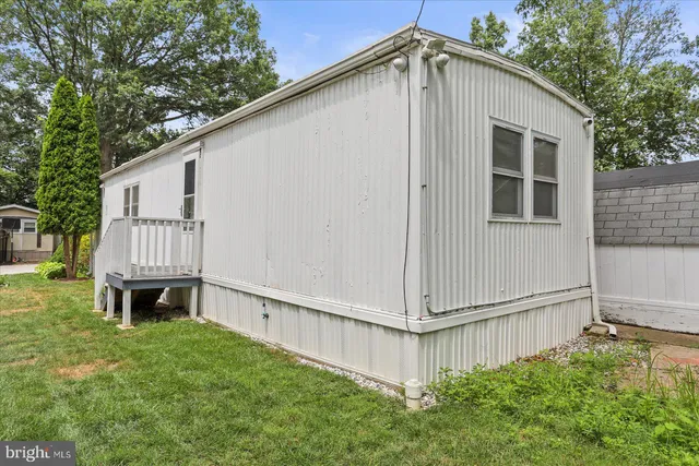 a backyard of a house with large tree and wooden fence