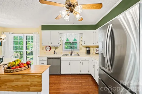 a kitchen with stainless steel appliances a stove a refrigerator and a fireplace