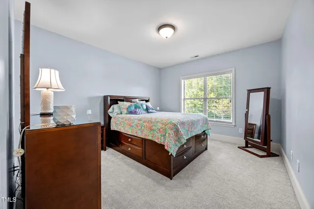 a spacious bedroom with a bed and wooden floor