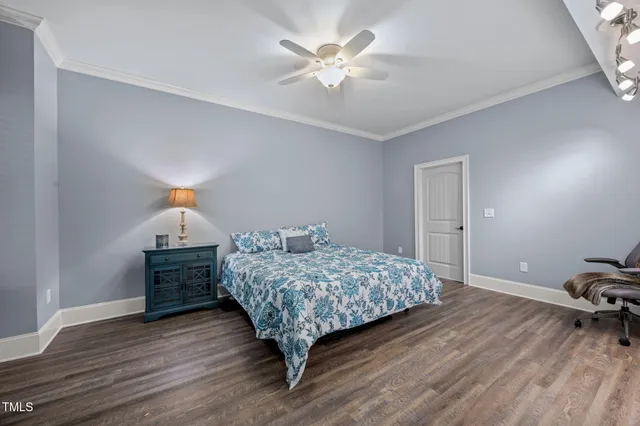 an aerial view of a residential houses with outdoor space and trees all around