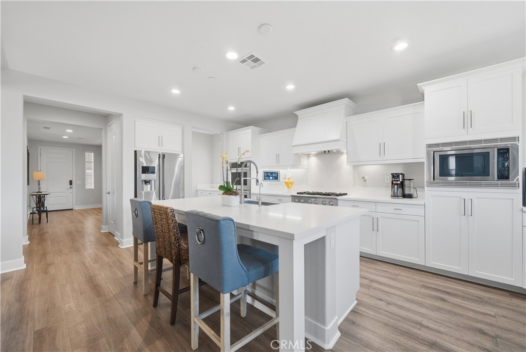 346 Ventasso Way Fallbrook, CA 92028 - Photo 11 of 56 a kitchen with white cabinets and stainless steel appliances
