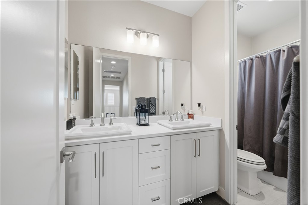 346 Ventasso Way Fallbrook, CA 92028 - Photo 39 of 56 a bathroom with a double vanity sink toilet and mirror