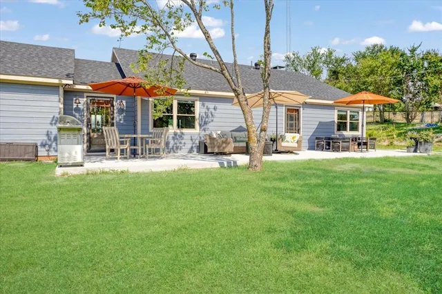 a patio with a table and chairs under an umbrella