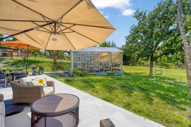 a view of a backyard with table and chairs under an umbrella