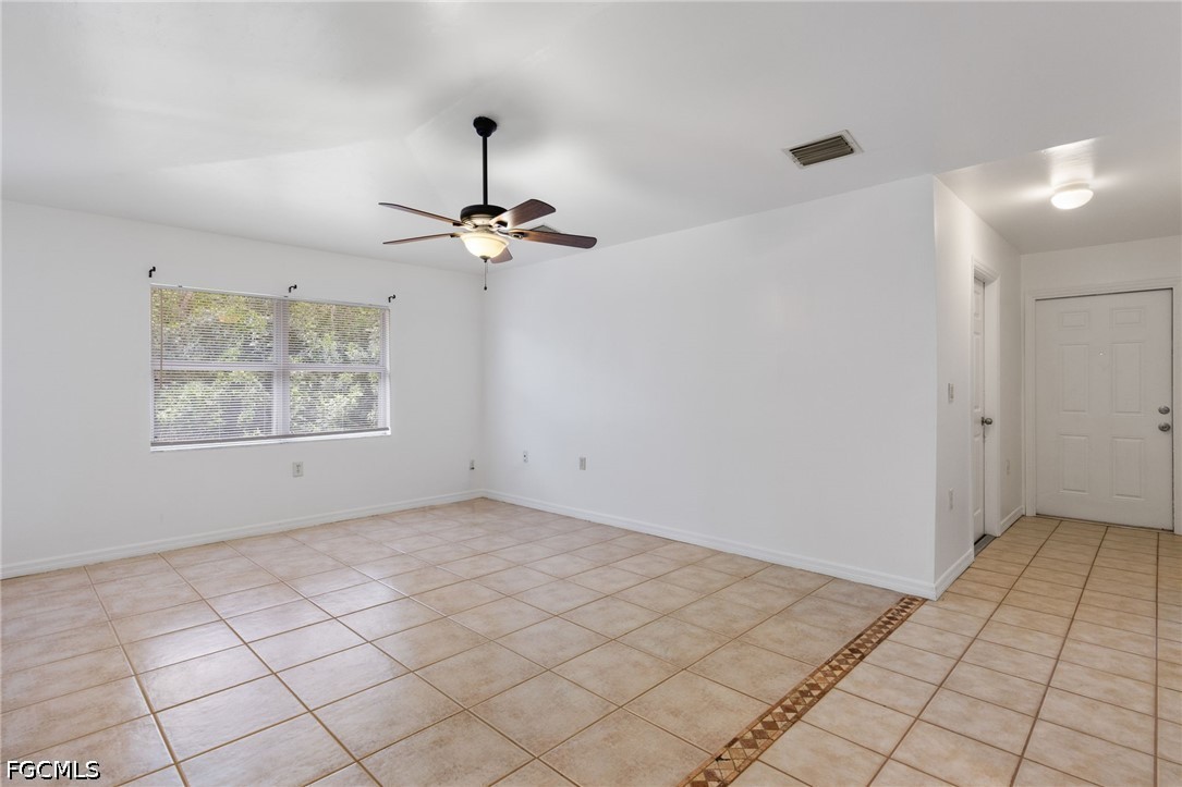 221 Meadow Road Lehigh Acres, FL 33973 - Photo 4 of 13 a view of an empty room and a chandelier fan