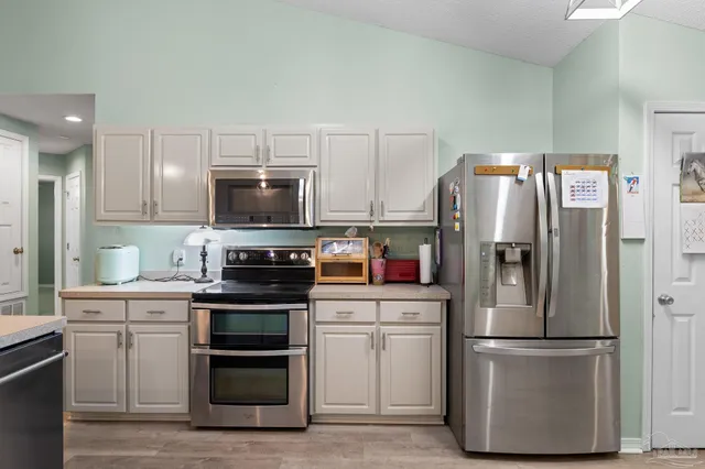 a kitchen with stainless steel appliances a refrigerator stove and microwave