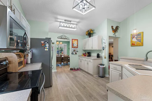 a kitchen with white cabinets and refrigerator