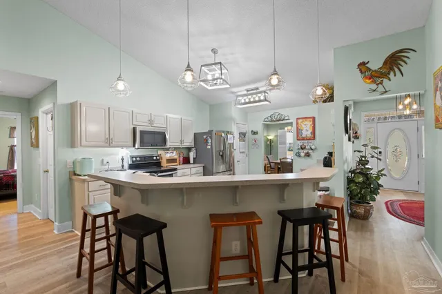 a kitchen with stainless steel appliances a dining table chairs and chandelier
