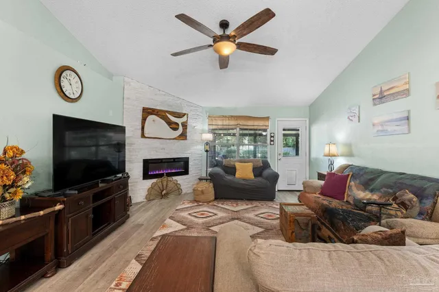 a living room with furniture a fireplace and a flat screen tv
