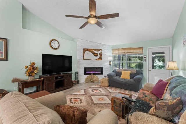 a living room with furniture a flat screen tv and a fireplace