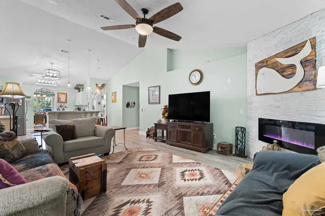 a living room with furniture a flat screen tv and a fireplace