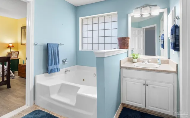 a bathroom with a tub sink and mirror