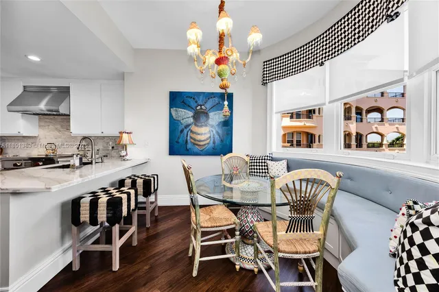 a dining room with furniture a chandelier and wooden floor
