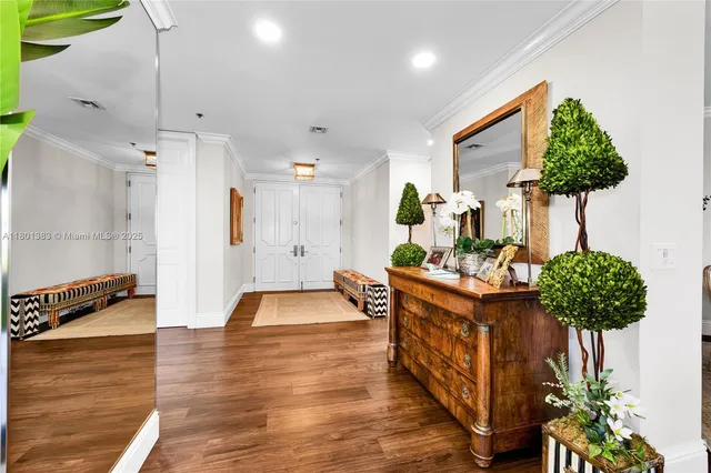 a living room with furniture large windows and wooden floor