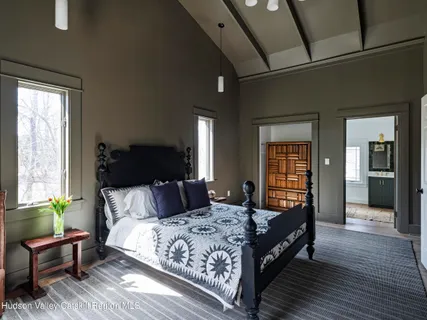 a bedroom with a bed couch and windows
