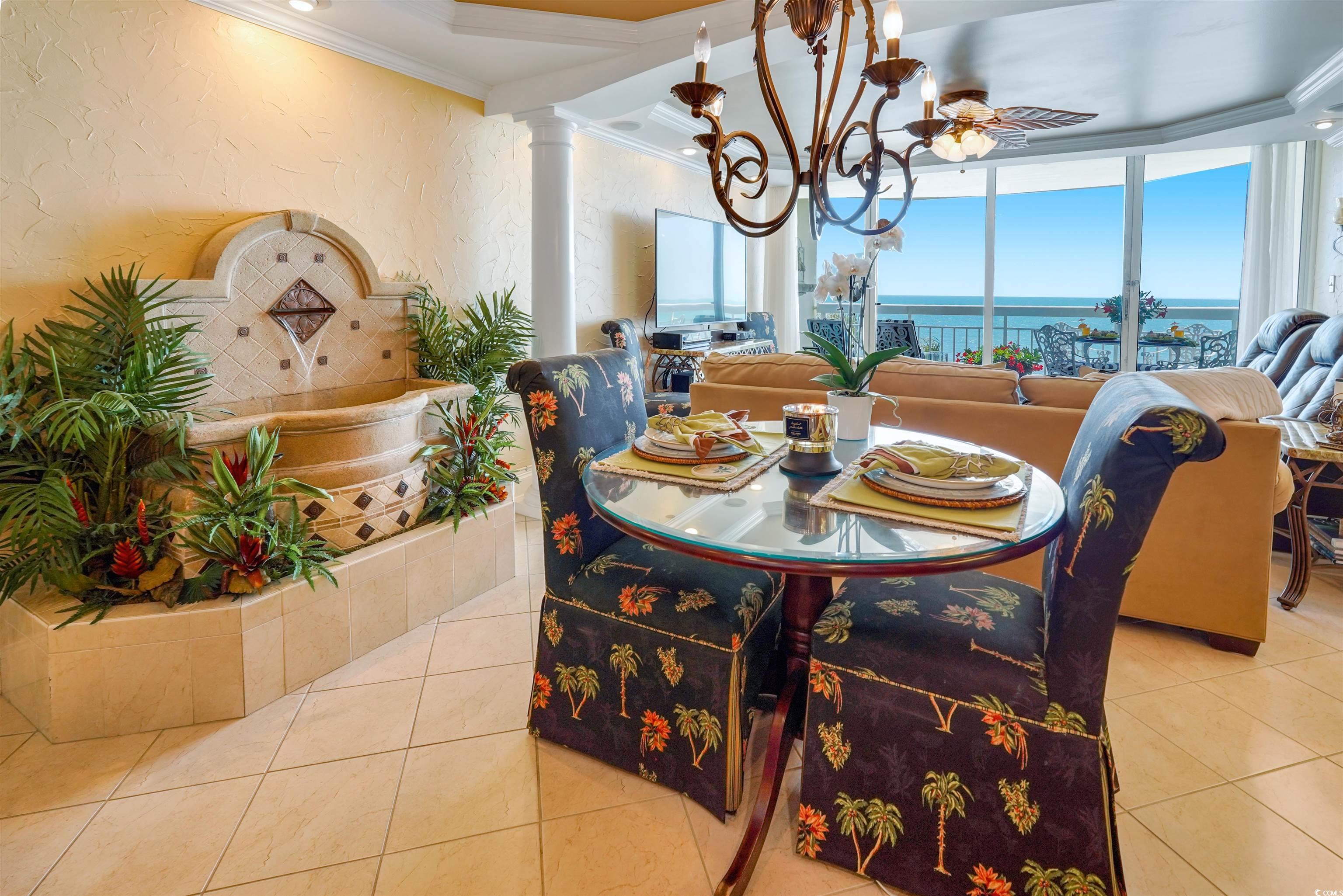 1012 North Waccamaw Drive, Unit 305 Murrells Inlet, SC 29576 - Photo 14 of 38 Tiled dining area with ornamental molding, a chandelier, decorative columns, a water view, and a textured wall