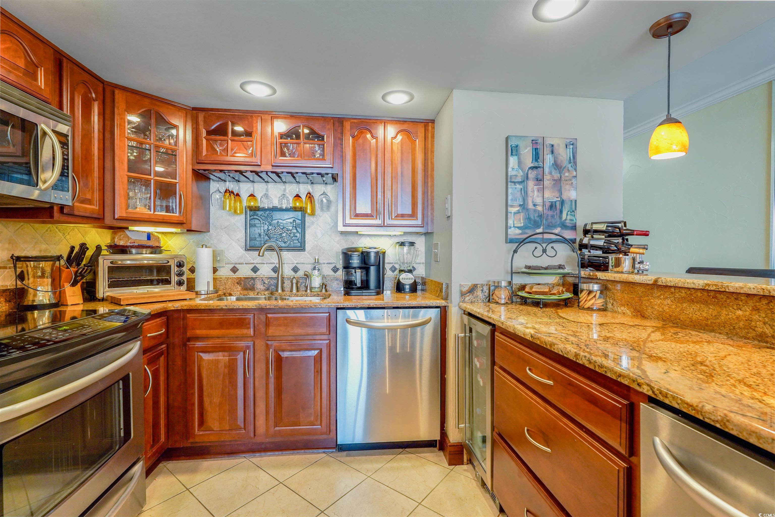 1012 North Waccamaw Drive, Unit 305 Murrells Inlet, SC 29576 - Photo 16 of 38 Kitchen featuring stainless steel appliances, a sink, wine cooler, light stone countertops, and backsplash