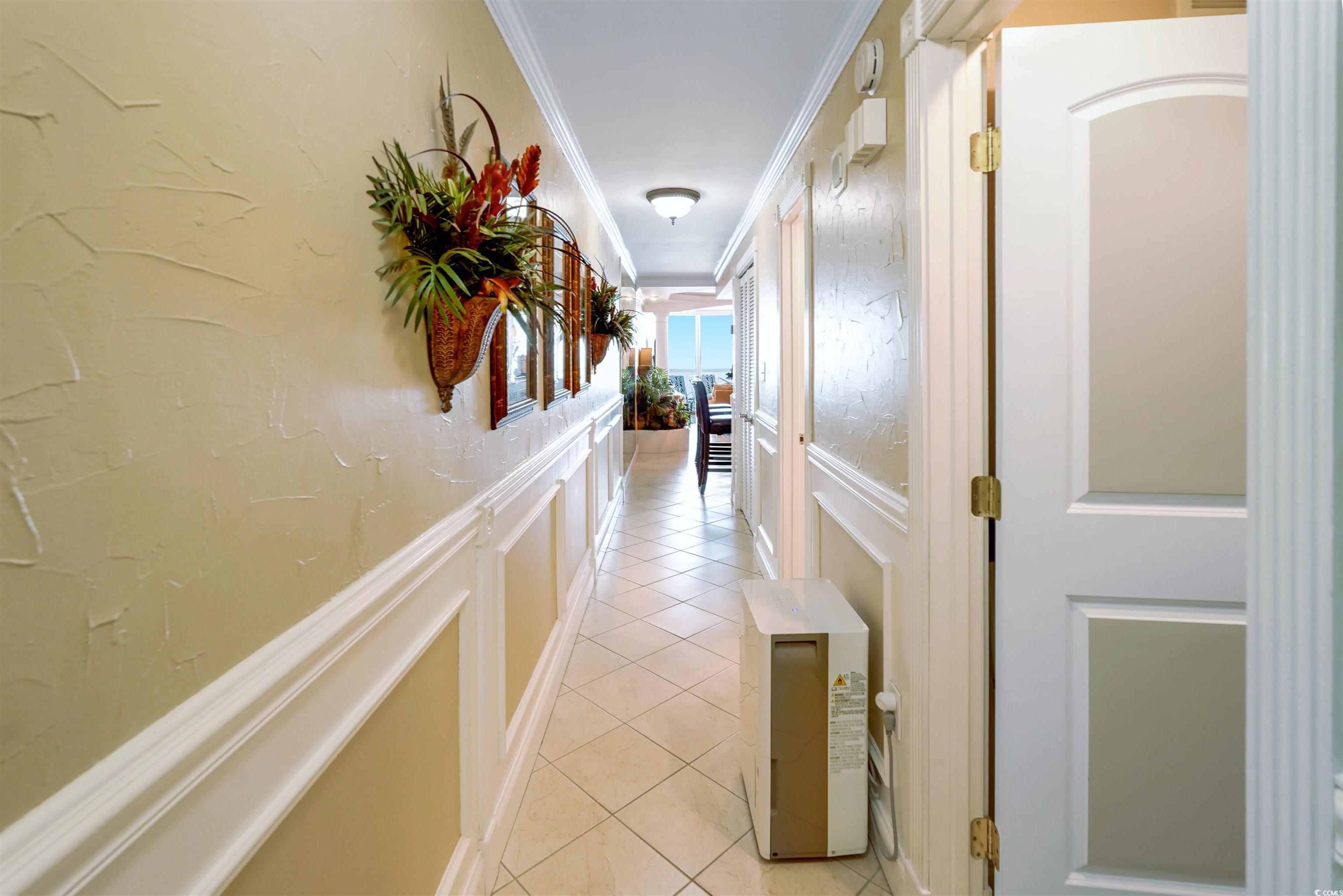 1012 North Waccamaw Drive, Unit 305 Murrells Inlet, SC 29576 - Photo 20 of 38 Corridor with ornamental molding, light tile patterned floors, and a decorative wall