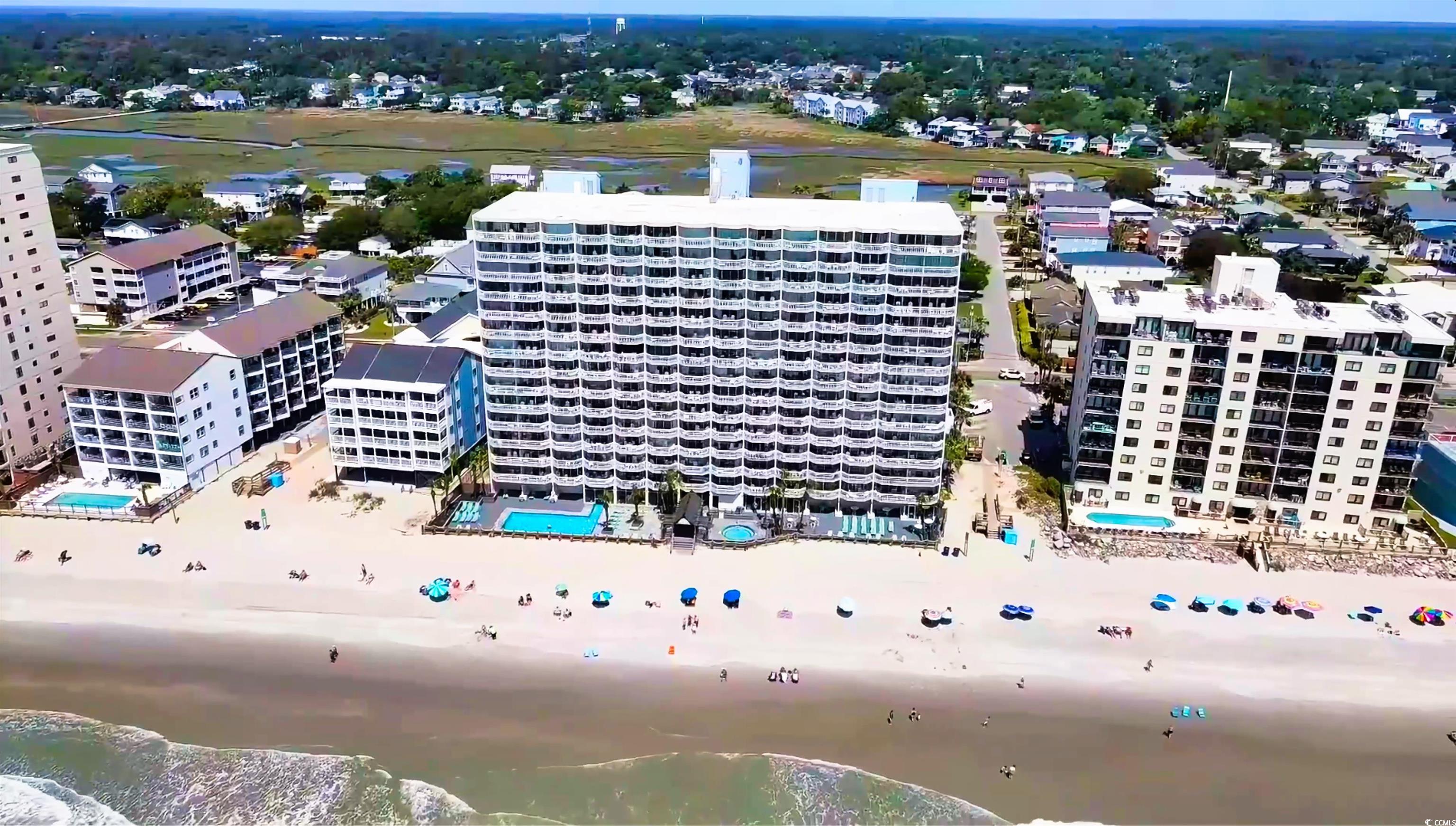 1012 North Waccamaw Drive, Unit 305 Murrells Inlet, SC 29576 - Photo 2 of 38 Drone / aerial view of a pool, apartment complex / building, and a large body of water