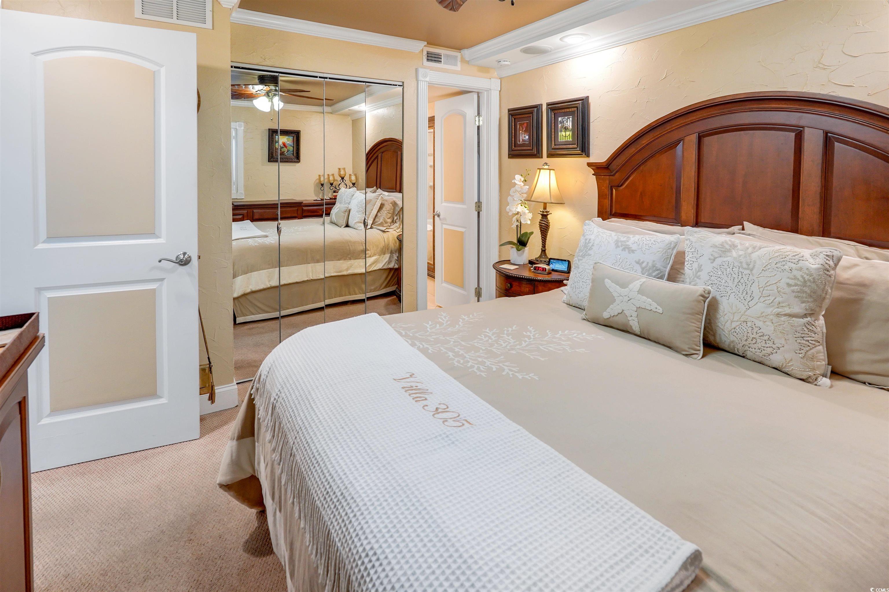1012 North Waccamaw Drive, Unit 305 Murrells Inlet, SC 29576 - Photo 25 of 38 Bedroom featuring ornamental molding, light colored carpet, a closet, and a ceiling fan