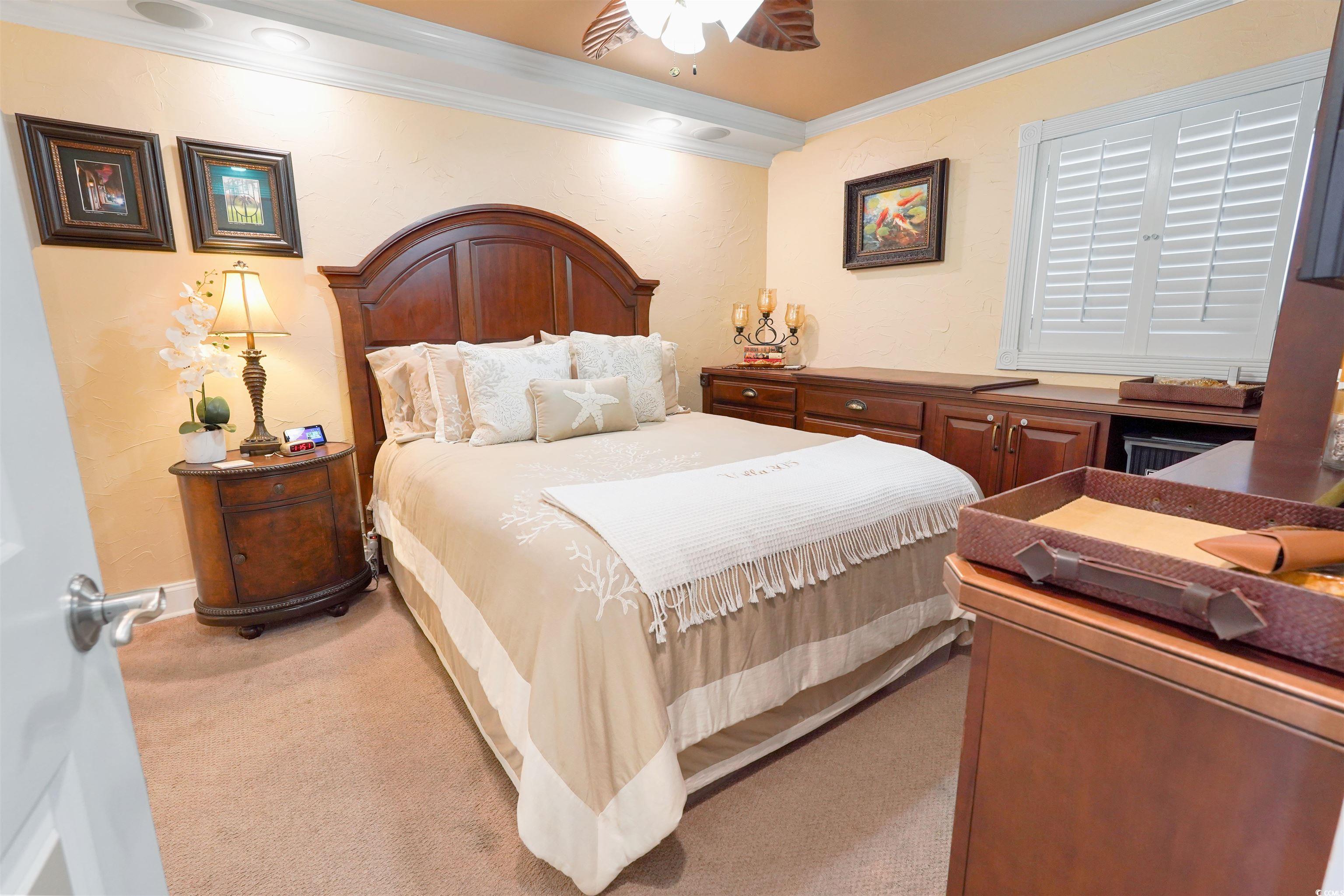 1012 North Waccamaw Drive, Unit 305 Murrells Inlet, SC 29576 - Photo 26 of 38 Carpeted bedroom with crown molding, ceiling fan, and baseboards