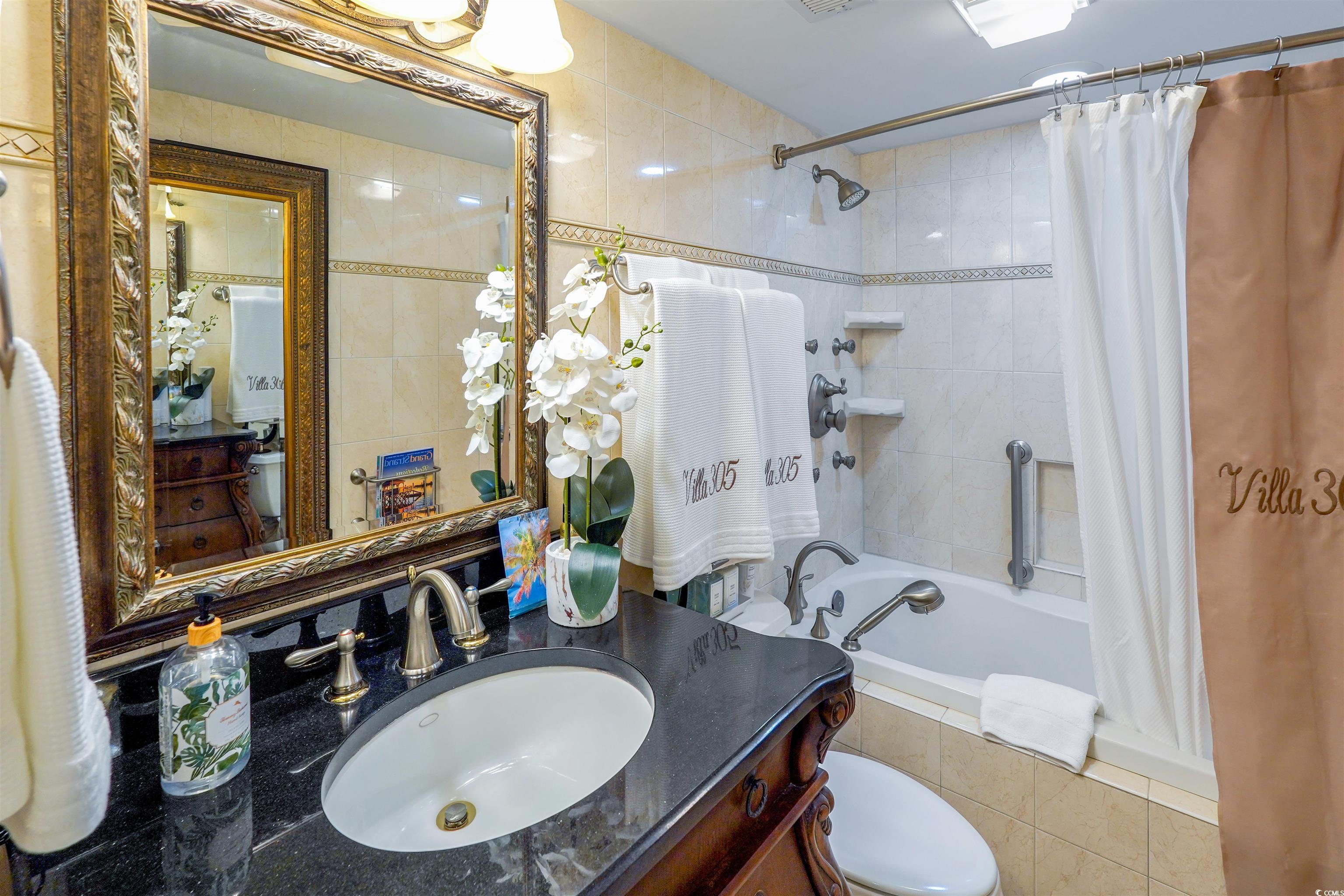 1012 North Waccamaw Drive, Unit 305 Murrells Inlet, SC 29576 - Photo 28 of 38 Full bath featuring toilet, tiled shower / bath combo, and vanity