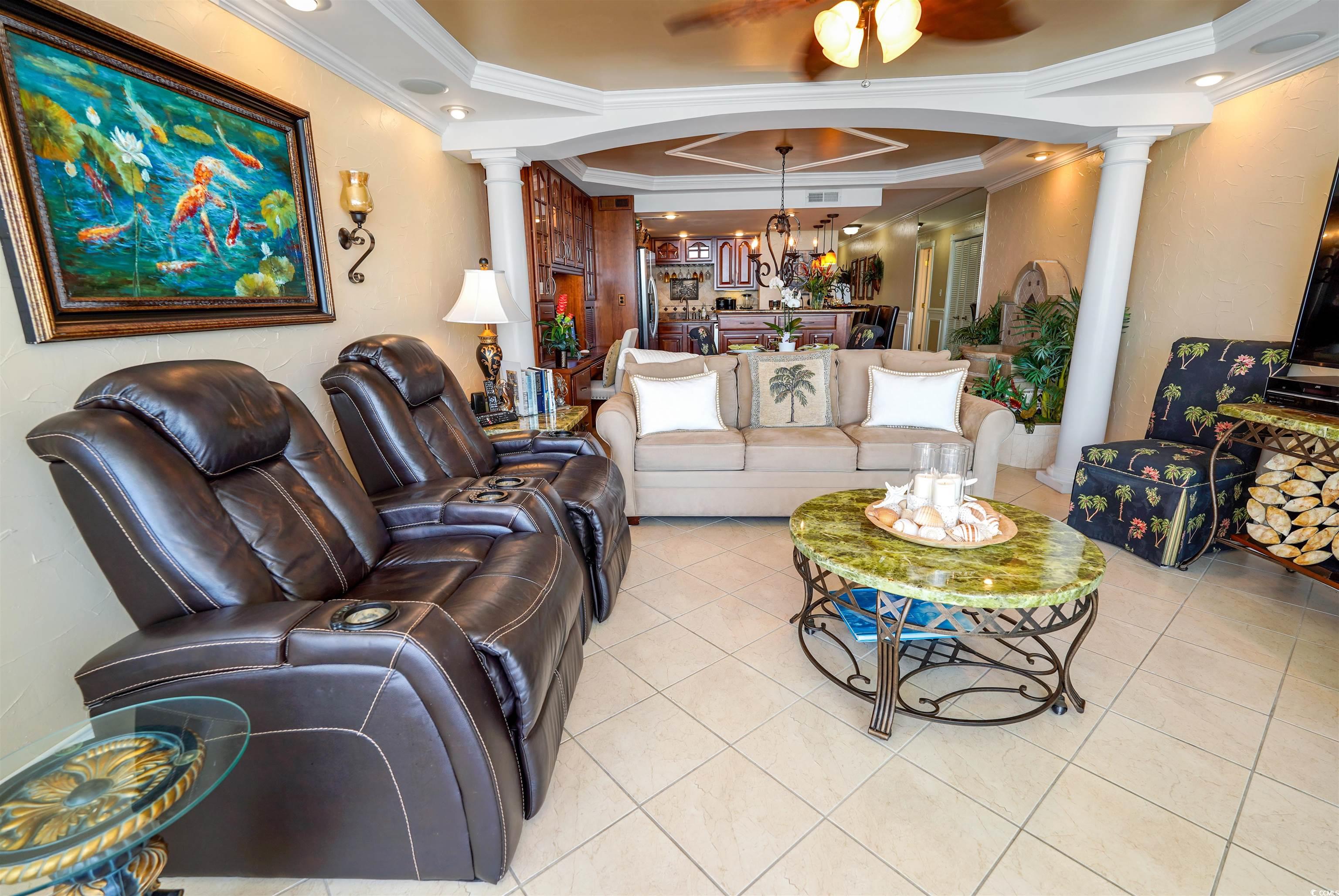 1012 North Waccamaw Drive, Unit 305 Murrells Inlet, SC 29576 - Photo 6 of 38 Living room featuring decorative columns, crown molding, light tile patterned floors, a chandelier, and ceiling fan