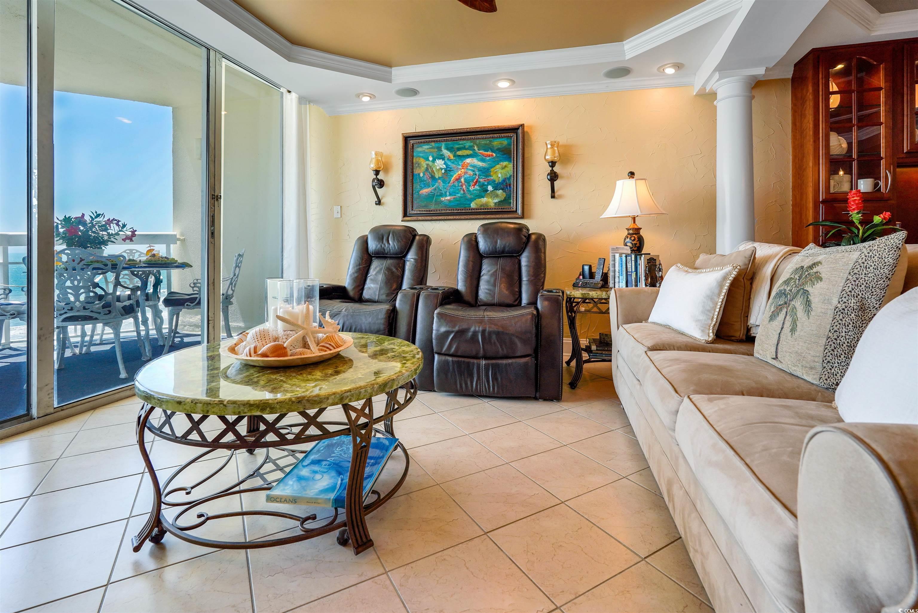 1012 North Waccamaw Drive, Unit 305 Murrells Inlet, SC 29576 - Photo 10 of 38 Living room with ornamental molding, a raised ceiling, light tile patterned flooring, and ornate columns