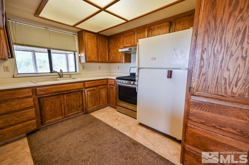 559 Mule Deer Road Coleville, CA 96107 - Photo 22 of 40 a kitchen with cabinets a window and stainless steel appliances