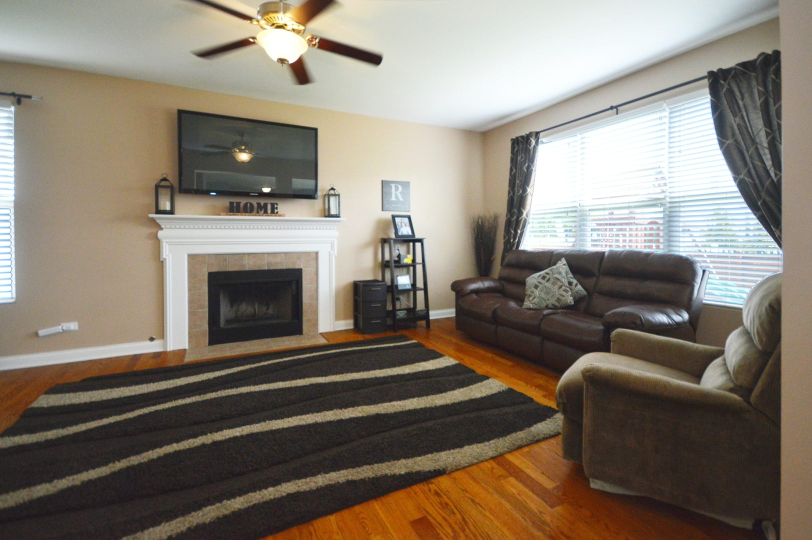 1504 Roth Drive Joliet, IL 60431 - Photo 11 of 27 a living room with furniture a fireplace and a flat screen tv