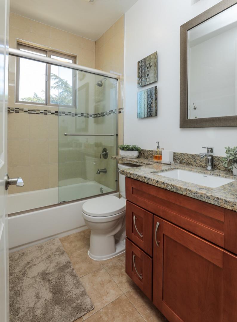 932 Marion Way Sunnyvale, CA 94087 - Photo 20 of 37 a bathroom with a granite countertop toilet sink and mirror