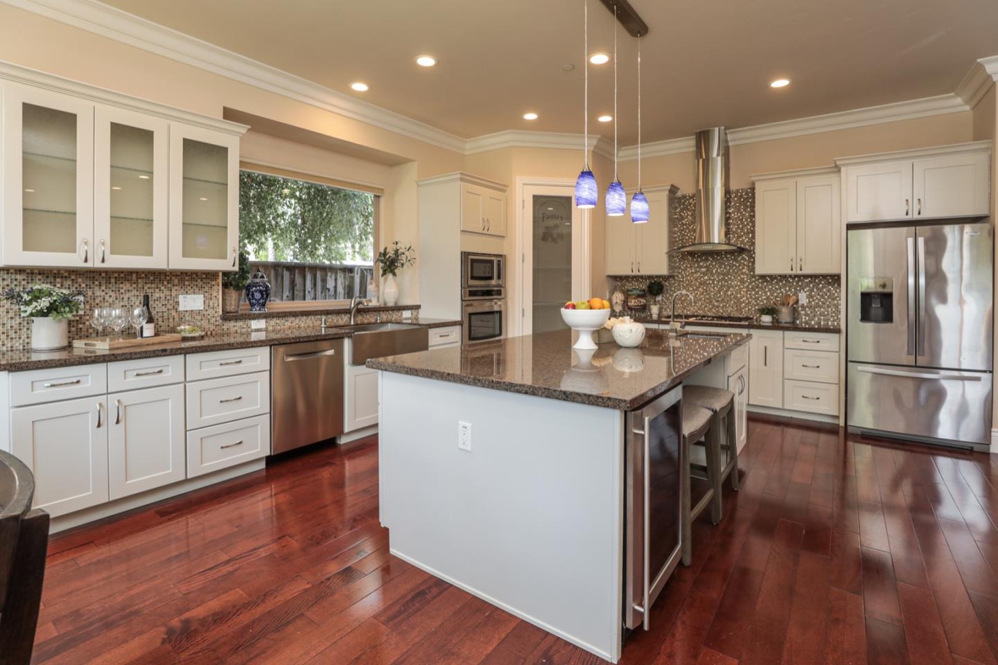 932 Marion Way Sunnyvale, CA 94087 - Photo 7 of 37 a kitchen with stainless steel appliances kitchen island granite countertop a stove a sink a refrigerator and white cabinets with wooden floor