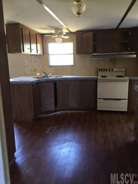3337 Deal Mill Road Hudson, NC 28638 - Photo 14 of 14 a kitchen with stainless steel appliances wooden floors and wooden cabinets
