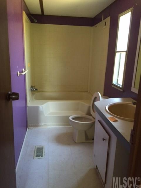 3337 Deal Mill Road Hudson, NC 28638 - Photo 4 of 14 a bathroom with a sink a toilet a tub and mirror