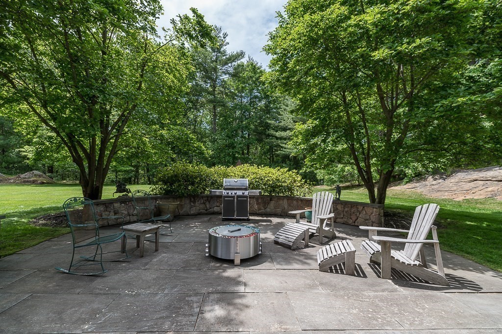 108 Grapevine Road Wenham, MA 01984 - Photo 3 of 37 a view of a patio with table and chairs and a barbeque with wooden fence and plants